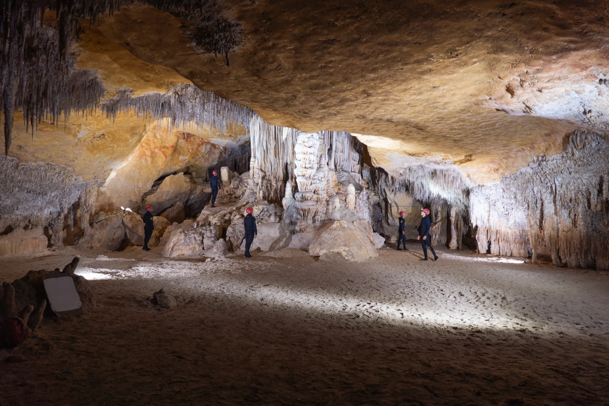 Small group of visitors in wetsuits on a guided sea cave boat trip from Porto Cristo